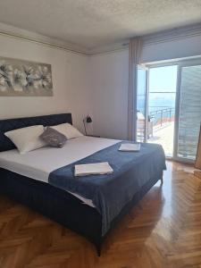 een slaapkamer met een groot bed en een groot raam bij Apartment Sanja in Senj