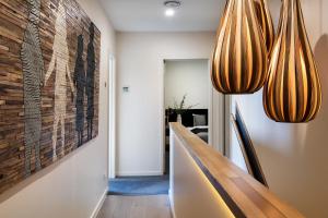 a hallway with two lights and a wall with a painting at Daybreaker Daylesford in Daylesford
