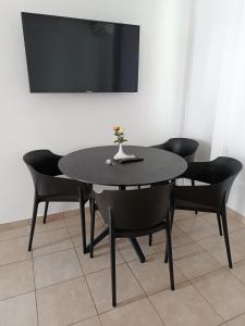 a black table with black chairs and a tv at Georgia Hotel Apartments in Protaras