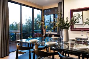 a dining room with a glass table and chairs at Daybreaker Daylesford in Daylesford