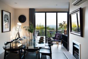 a dining room with a glass table and chairs at Daybreaker Daylesford in Daylesford