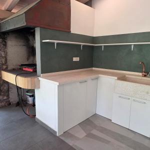 a kitchen with white cabinets and a counter top at Holiday House Hlad in Baška +30 photos
