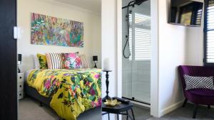 a bedroom with a yellow bed and a painting on the wall at LACROIX - DAYLESFORD in Daylesford