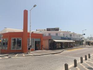 a person standing in front of a store on a street at Georgia Hotel Apartments in Protaras