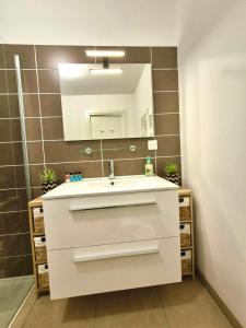 a bathroom with a white sink and a mirror at T2 de standing front de mer in Propriano