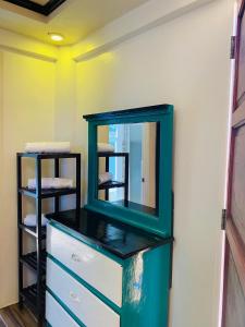 a green dresser with a mirror on a wall at Couple room C in Final Destination Resort in Bolinao