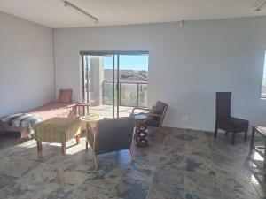 a living room with a bed and a table and chairs at Barefoot Bliss Holiday Home in Port Alfred