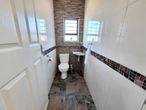 a bathroom with a toilet and a sink at Barefoot Bliss Holiday Home in Port Alfred +18 photos