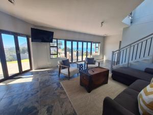 a living room with a couch and a table at Barefoot Bliss Holiday Home in Port Alfred