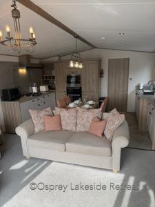 a living room with a couch and a kitchen at Lakeside Retreat with hot tub and fishing peg on Osprey Rise at Tattershall Lakes Country Park in Tattershall