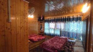 a bedroom with two beds in a wooden room at HOTEl momin in Srinagar +18 photos