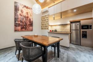a kitchen with a wooden table and chairs at Villa Domus A1 in Sanur