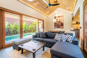 a living room with a couch and a table at Villa Domus A1 in Sanur +2 photos