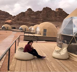 a woman sitting on a bean bag in the desert at Rum rose luxury camp in Wadi Rum