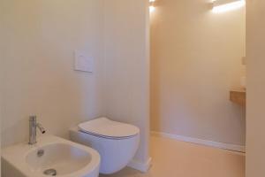 a bathroom with a white toilet and a sink at Farmhouse by the sea - Grilli 3 in Lacona +12 photos