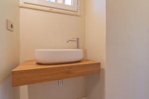 a bathroom with a white sink on a wooden counter at Farmhouse by the sea - Grilli 3 in Lacona
