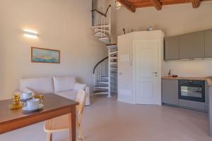 a living room with a couch and a table and a kitchen at Farmhouse by the sea - Grilli 3 in Lacona