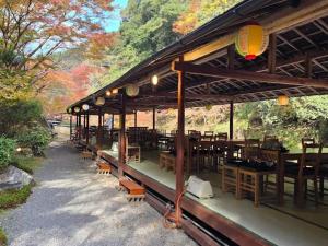a restaurant with wooden tables and chairs and trees at Takao Kanko Hotel in Kyoto