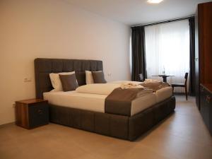 a bedroom with a large bed and a table at AS Aparthotel in Schorndorf