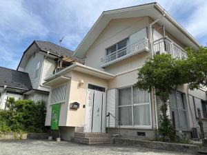 une maison blanche avec un balcon au-dessus dans l'établissement I LOVE HAKONE, à Hakone