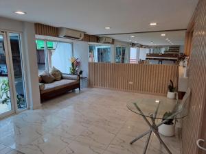 a living room with a glass table and a couch at Nantra Ploenchit hotel in Bangkok