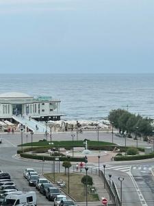 a parking lot with cars parked next to the ocean at Appartamento vacanze Rotonda Sunrise in Senigallia