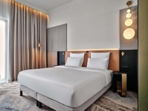 a large white bed in a hotel room at Mövenpick Grand Hotel Wroclaw in Wrocław +185 photos