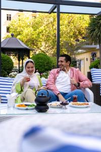 a man and a woman sitting at a table with food at Hyatt Regency Baku in Baku