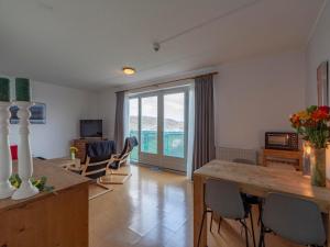 Sala de estar con mesa y sillas y vistas al océano en Cozy Stay Near Dunes, en Julianadorp