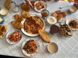 a table with many plates of food on it at East guest house in Tegermenti