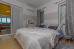 a bedroom with two beds and a large window at Villa Mali Jardin in Grižane +42 photos