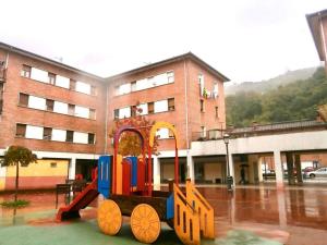 a train on a playground in front of a building at Apartamento con vistas Santa Maria in San Martín del Rey Aurelio