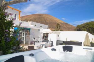 a view of a house with a thatched hill in the background at CASA RURAL GA7COLORES only adult in Montaña Blanca