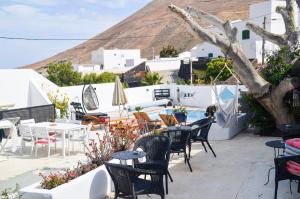 a patio with tables and chairs with a mountain in the background at CASA RURAL GA7COLORES only adult in Montaña Blanca