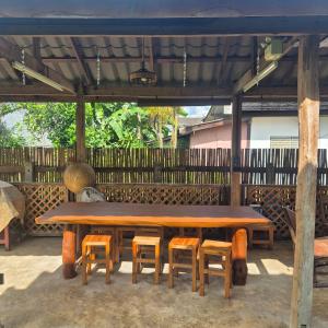 a wooden table and chairs under a pavilion at Kedthawa Homestay เฮือนภูผา in Ban Cho Lae