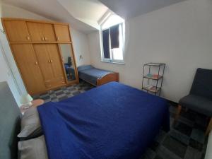 a bedroom with a blue bed and a chair at Apartman Renata in Pula