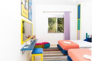 a bedroom with two beds and a desk and a window at Dar Al Khattar 4 BR in Batroun with Pool in Batroûn