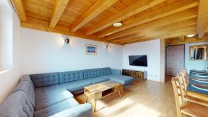 a living room with a blue couch and a table at Pracondu 2 502 - OUTDOOR & FUN charming apartment in Nendaz