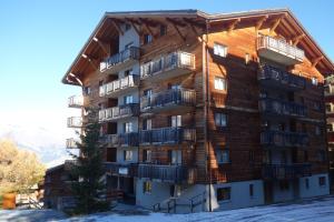a large apartment building with balconies in the snow at Pracondu 2 502 - OUTDOOR & FUN charming apartment in Nendaz