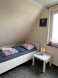 a small bedroom with a bed and a table at Pension Highway Löhne in Löhne +3 photos
