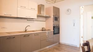 a kitchen with white cabinets and a clock on the wall at Teuladamar by Rentbeat in SantʼAnna Arresi