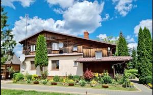 a house with a lot of plants in front of it at Nad stawami - apartament in Białowieża