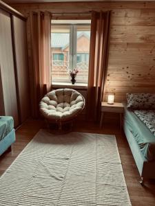 a living room with a chair and a window at Nad stawami - apartament in Białowieża