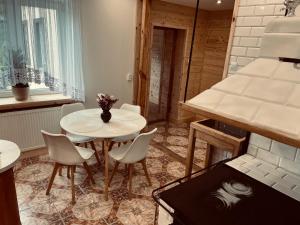 a kitchen with a table and chairs in a room at Nad stawami - apartament in Białowieża