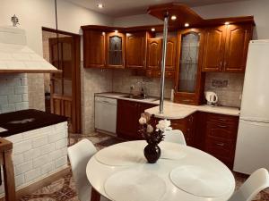a kitchen with a table with a vase of flowers on it at Nad stawami - apartament in Białowieża +7 photos