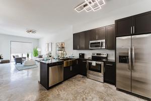 a kitchen with black cabinets and stainless steel appliances at Ultra Luxe Apartment in Prime Location in Fort Lauderdale