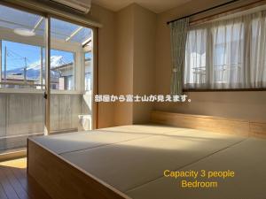 Un dormitorio con una cama grande frente a una ventana. en Vacation Rental TOKIWA, en Fujiyoshida