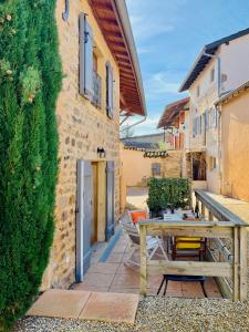 a patio with a wooden table next to a building at Bienvenue au Clos d Albertine in Lancié