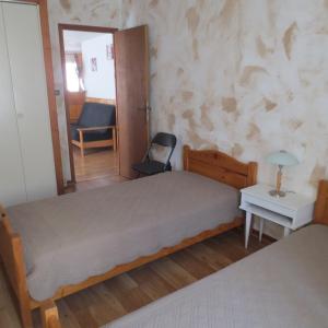 - une chambre avec un lit, un miroir et une chaise dans l'établissement Appartement Les Iris, à Luz-Saint-Sauveur