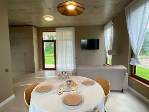 a dining room with a white table and chairs at Villa on the sands in Ureki
